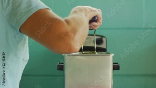 Woman removing food from a deep fryer photo