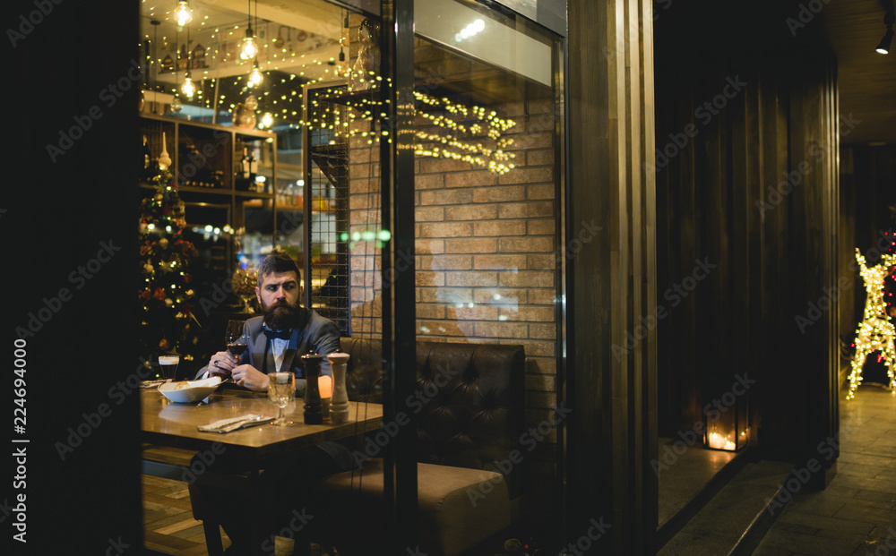 Bearded man rest in restaurant with wine glass. Bearded man wait in bar and drink wine.