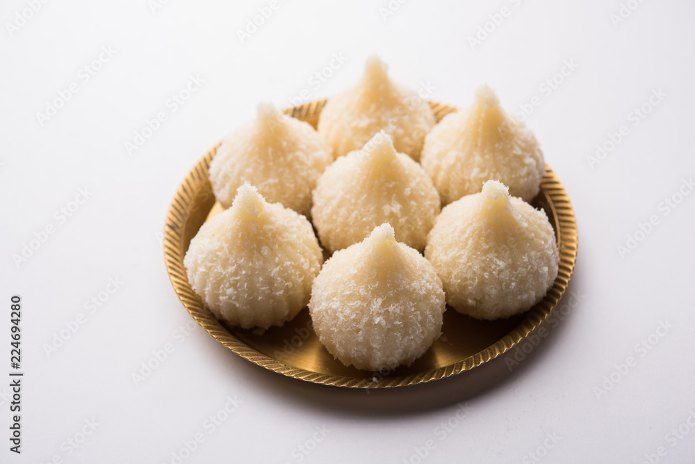 Sweet Modak made using coconut, khoya and sugar. Popular Maharashtrian recipe offered to lord Ganesha in Ganesh Festival. Served in a plate. Selective focus Sweet Modak made using coconut, khoya and sugar. Popular Maharashtrian recipe offered to lord Ganesha in Ganesh Festival. Served in a plate. Selective focus