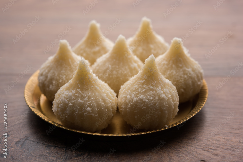 Sweet Modak made using coconut, khoya and sugar. Popular Maharashtrian recipe offered to lord Ganesha in Ganesh Festival. Served in a plate. Selective focus Sweet Modak made using coconut, khoya and sugar. Popular Maharashtrian recipe offered to lord Ganesha in Ganesh Festival. Served in a plate. Selective focus