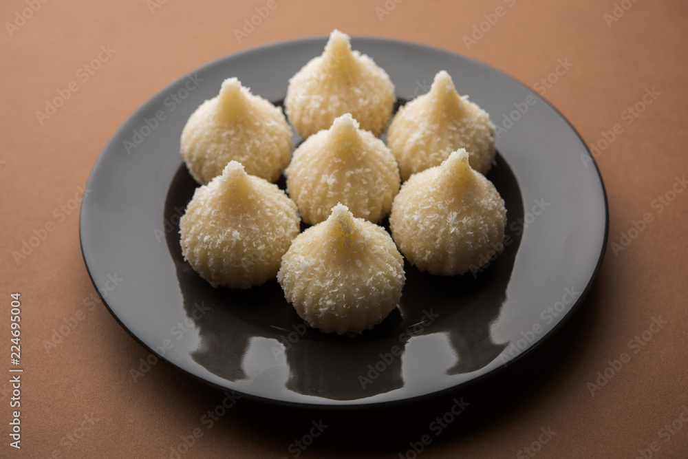 Sweet Modak made using coconut, khoya and sugar. Popular Maharashtrian recipe offered to lord Ganesha in Ganesh Festival. Served in a plate. Selective focus Sweet Modak made using coconut, khoya and sugar. Popular Maharashtrian recipe offered to lord Ganesha in Ganesh Festival. Served in a plate. Selective focus