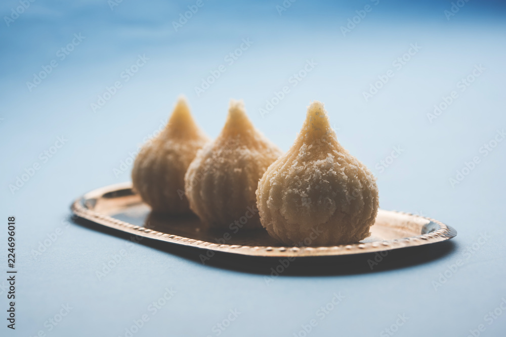Sweet Modak made using coconut, khoya and sugar. Popular Maharashtrian recipe offered to lord Ganesha in Ganesh Festival. Served in a plate. Selective focus Sweet Modak made using coconut, khoya and sugar. Popular Maharashtrian recipe offered to lord Ganesha in Ganesh Festival. Served in a plate. Selective focus