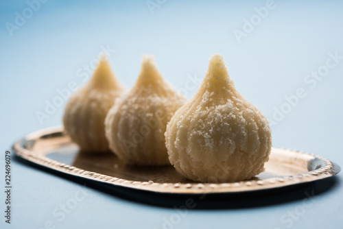 Sweet Modak made using coconut, khoya and sugar. Popular Maharashtrian recipe offered to lord Ganesha in Ganesh Festival. Served in a plate. Selective focus photo