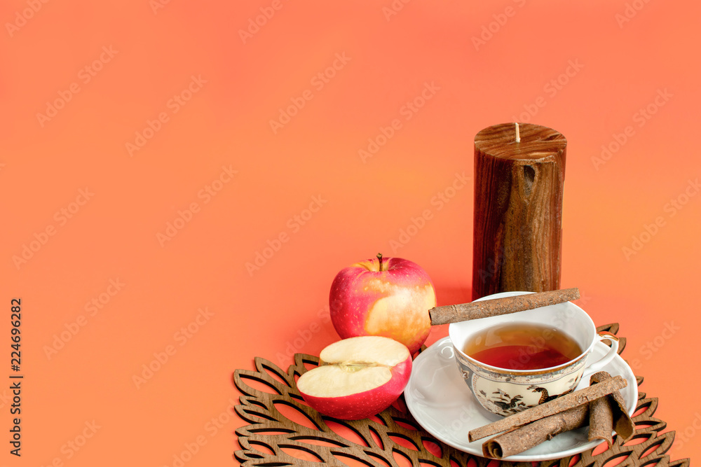 Autumn afternoon hot tea, apple and cinnamon flavour, orange background - obrazy, fototapety, plakaty 