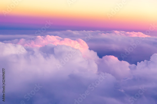 Beautiful sunset sky above clouds with nice dramatic light. View from airplane window