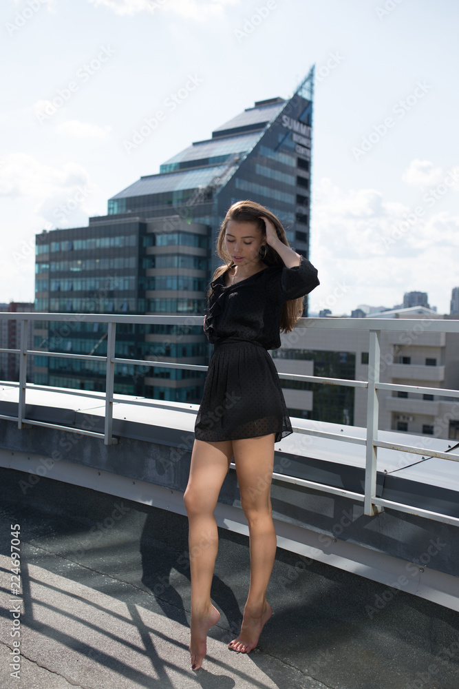 Young woman standing on the terrace overlooking the city.