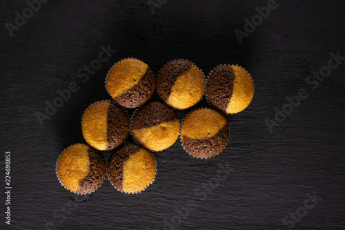 Group of eight whole fresh baked marble muffin flatlay on grey stone photo