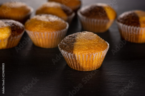 Lot of whole fresh baked marble muffin on grey stone