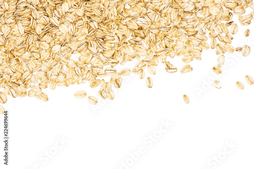 Lot of whole flat raw rolled oats above flatlay isolated on white background