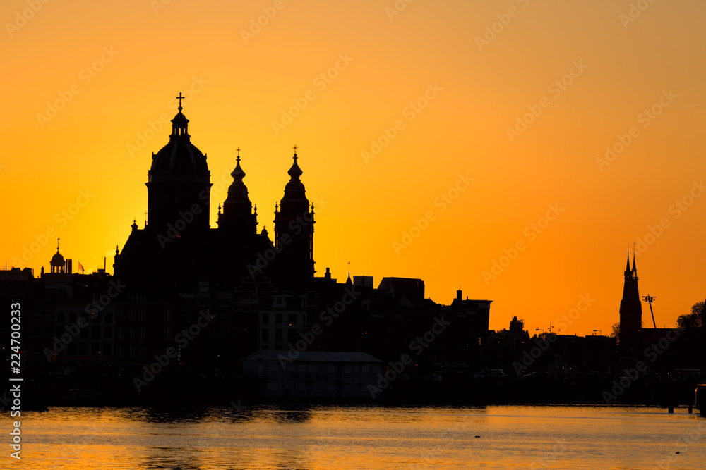 Amsterdam cityscape skyline with Church of Saint Nicholas Sint-Nicolaaskerk during sunset. Picturesque of Amsterdam, Netherlands. Iconic view