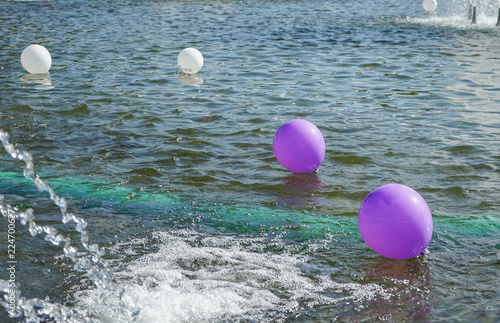 Balloons float on the surface of the water.