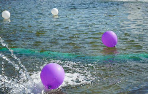 Balloons float on the surface of the water.