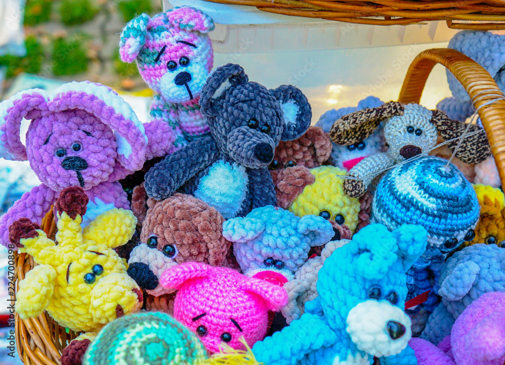 Knitted colorful toys of different animals in a street souvenir shop.
