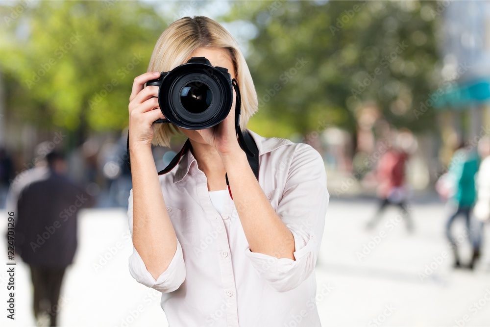 Young woman with camera taking photo