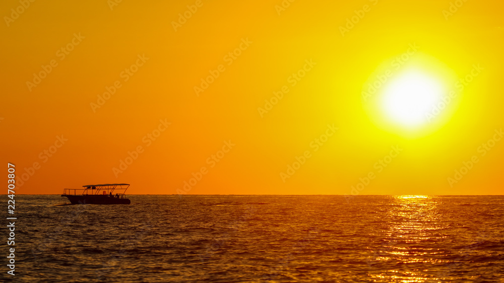 Boat on the sea in the rays of sunset