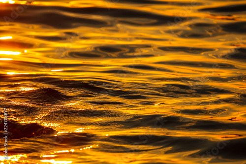 Smooth water in the sea in the rays of sunset