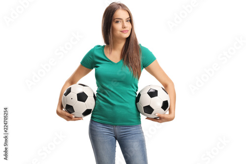 Beautiful young woman holding two soccer balls