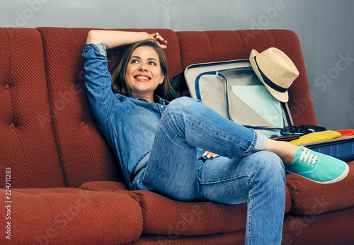 Young woman relaxing on couch in break between packing clothes