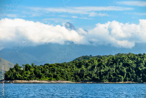 Island with tropical forest, blue sea, mountains and clouds in background, Angra dos Reis, Rio de Janeiro, Brazil © Raphael
