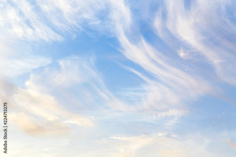 Soft white сirrus clouds against blue sky background