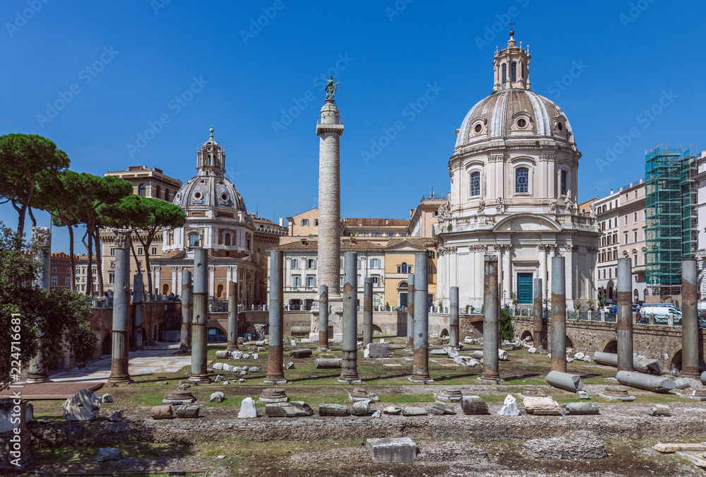 Trajan`s forum in Rome. Ancient Roman ruins of Trajan`s forum and Santi Luca e Martina church on a sunny day.