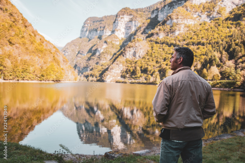 man looks at a mountain lake