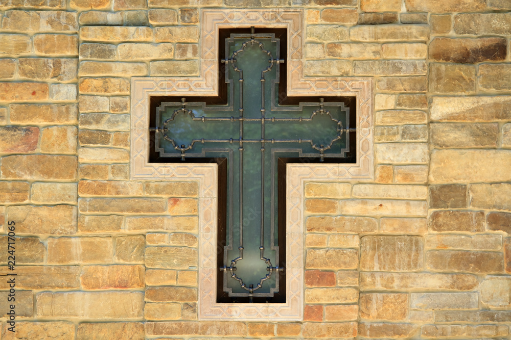 decorative metal cross on textured wall