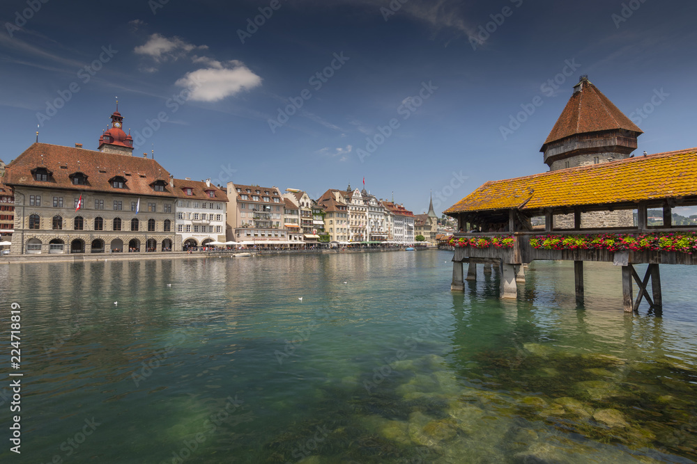 View of the old town with Town Hall and Chapel Bridge, wooden footbridge across the Reuss River in the city of Lucern, Switzerland.