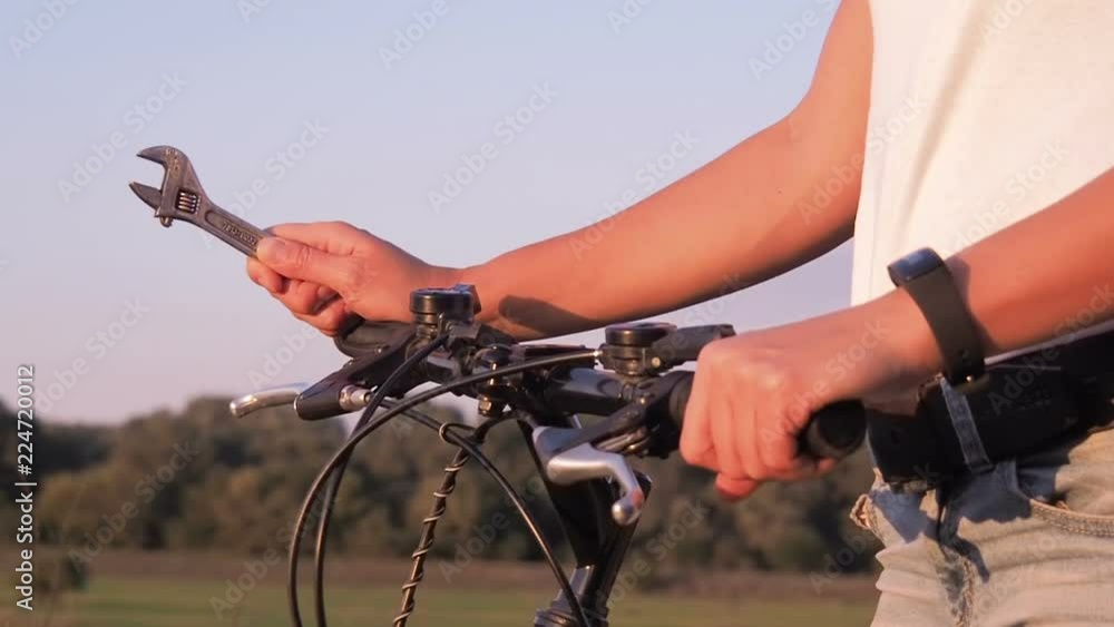 Bicycle repair. Cyclist with adjustable wrench. Bicycle repair. Cyclist with adjustable wrench.