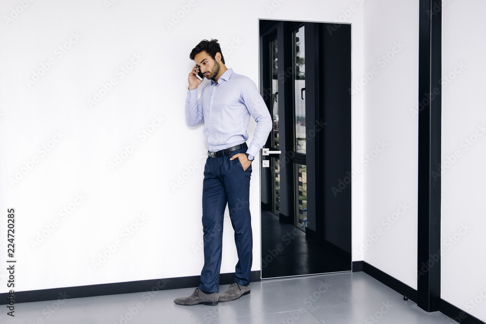 Young businessman using mobile phone in the office Young businessman using mobile phone in the office