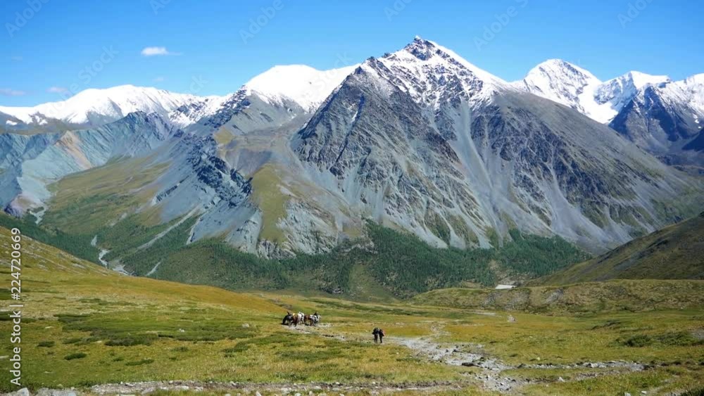 Mountains with snow-capped peaks.
Tourists go down the path in background of Altai mountains. Mountains with snow-capped peaks.
Tourists go down the path in background of Altai mountains.