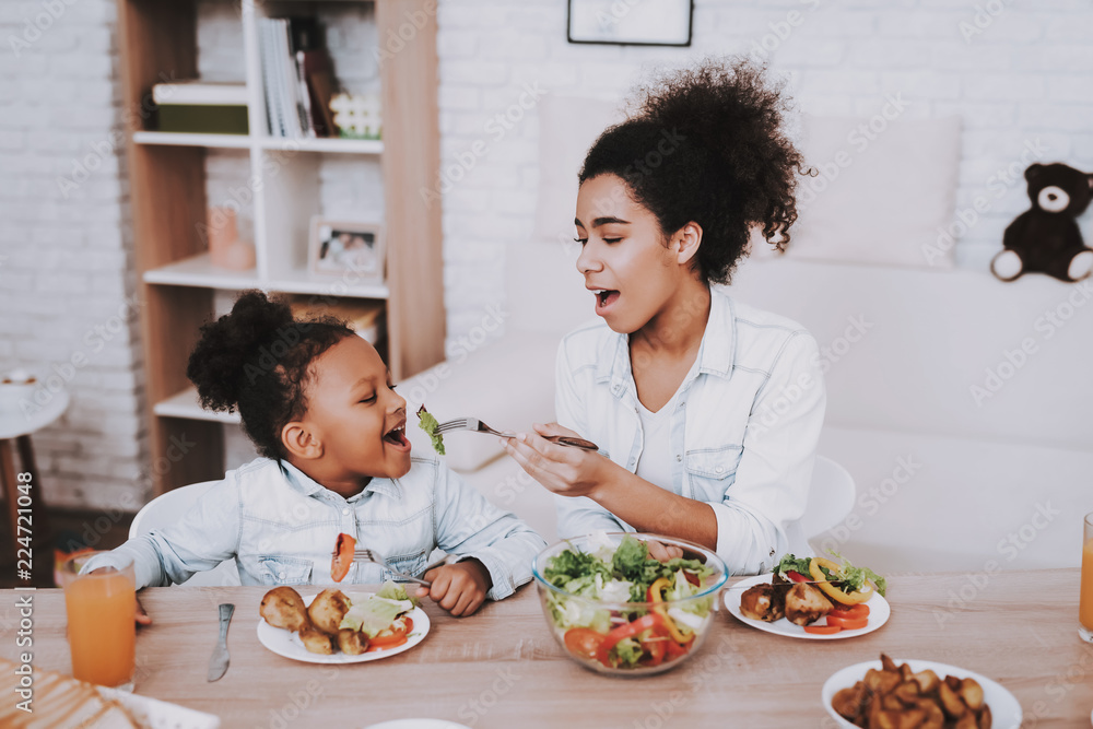 Mother Feeds Young Girl. Mom and Daughter Eat. Mother Feeds Young Girl. Mom and Daughter Eat.