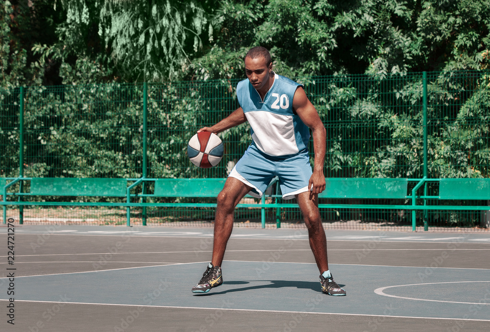 Picture of young confused african basketball player practicing outdoor. Fit afro man in motion and movement. athletic and sport lifestyle concept Picture of young confused african basketball player practicing outdoor. Fit afro man in motion and movement. athletic and sport lifestyle concept