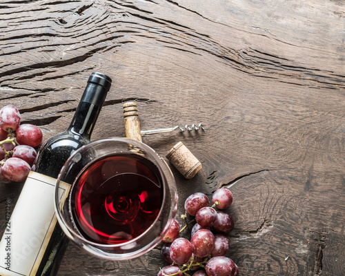 Wine glass, wine bottle and grapes on wooden background. Wine tasting.