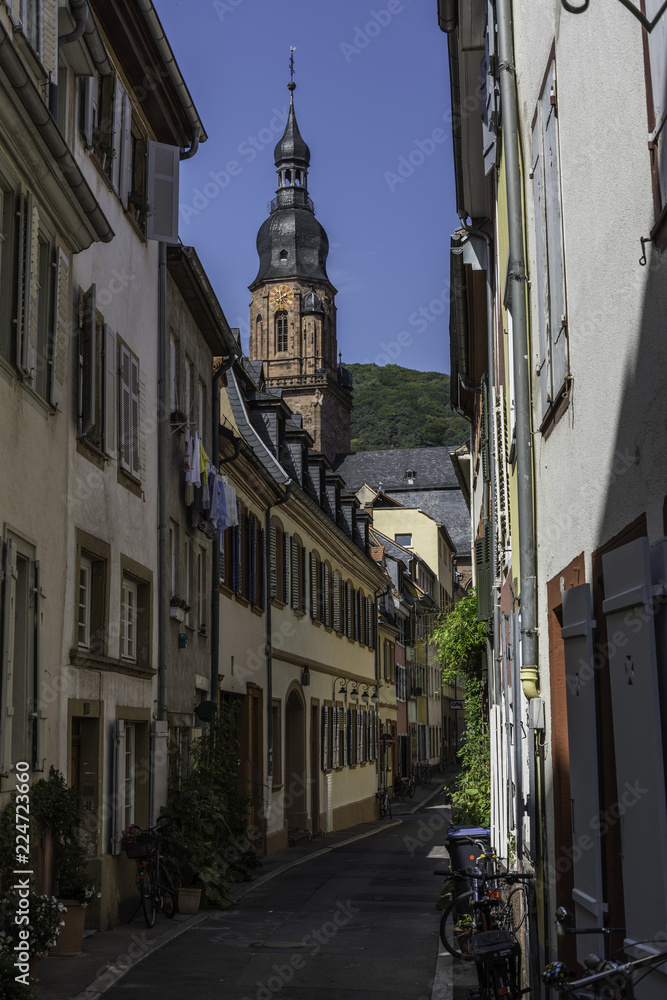 Busy city street in the popular european travel destination Heidelberg, Germany, Europe.  With the illustrious church of the holly spirit. shot on sunny day in summer.