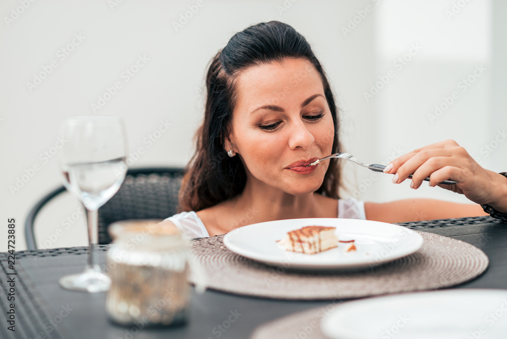 Close-up image of smiling woman eating piece of cake. Close-up image of smiling woman eating piece of cake.
