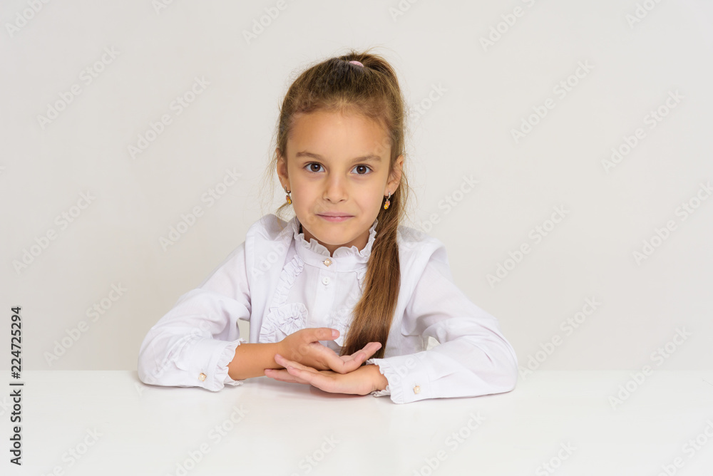 Portrait of a cute baby girl on a white background at the table. Portrait of a cute baby girl on a white background at the table.