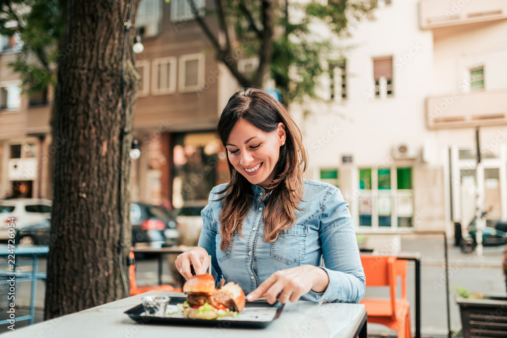 Young woman eating delicious food outdoors.