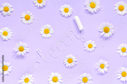 Word CLEAN from white thread hygienic female tampon and chamomiles on lilac background photo