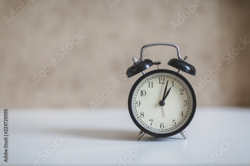 alarm clock on white table and brown background