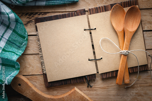 Blank vintage recipe cookbook and utensils on wooden background, top view, copy space