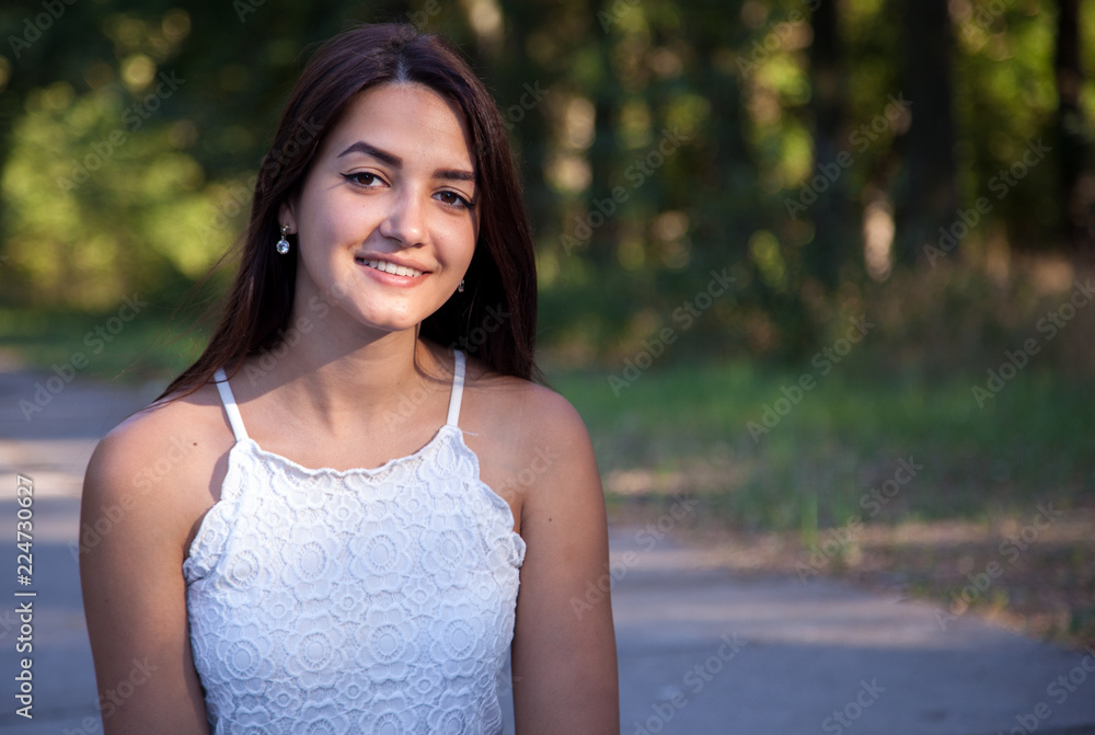 pretty young girl smiling in the park at sunset pretty young girl smiling in the park at sunset
