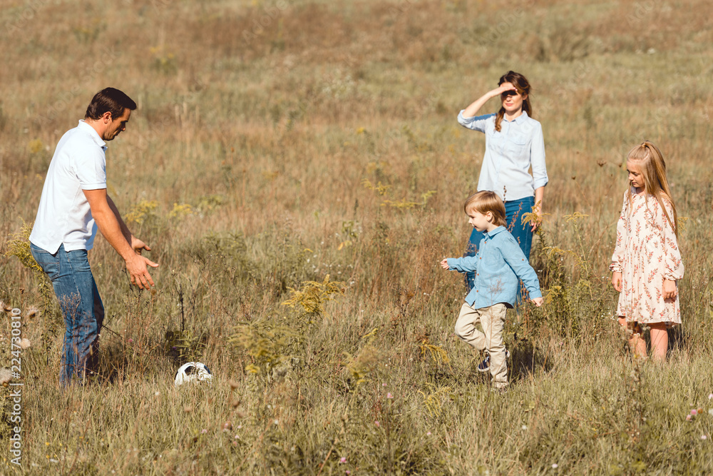 happy young family playing football together in nature happy young family playing football together in nature