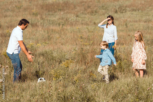 happy young family playing football together in nature