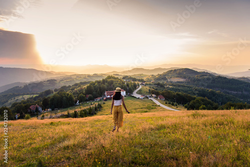 Woman walking down the hill at sunset