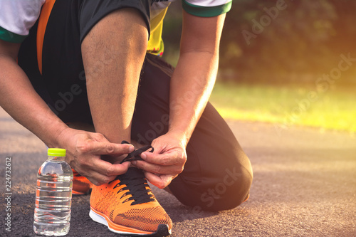 A man preparing and wearing sports shoes for jogging and exercise in the morning.