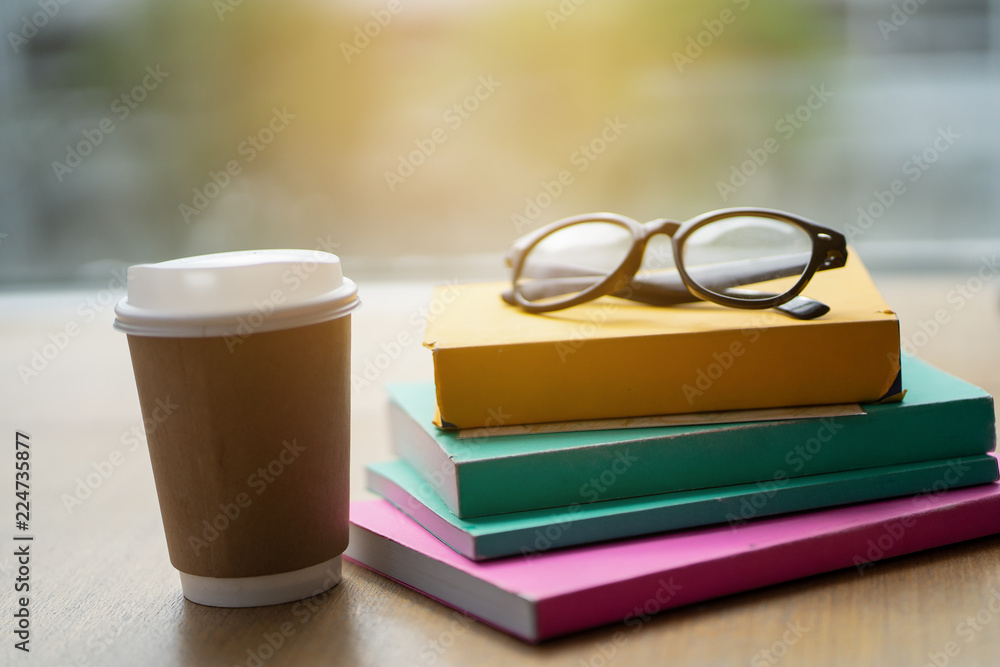 Many books are put on the table with coffee. Many books are put on the table with coffee.