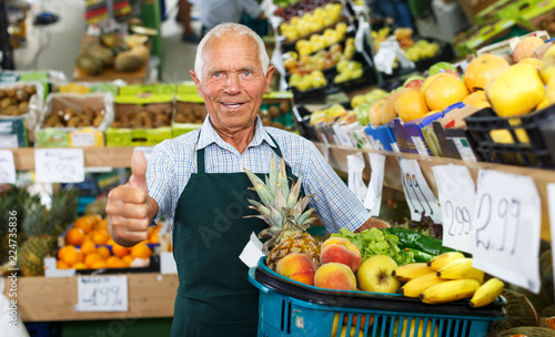 Salesman giving thumbs up in greengrocery