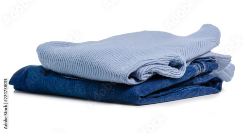 Stack of clothing blue jeans and blue sweaters on a white background isolation