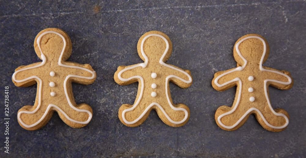Three Decorated Gingerbread Men on a Dark Surface